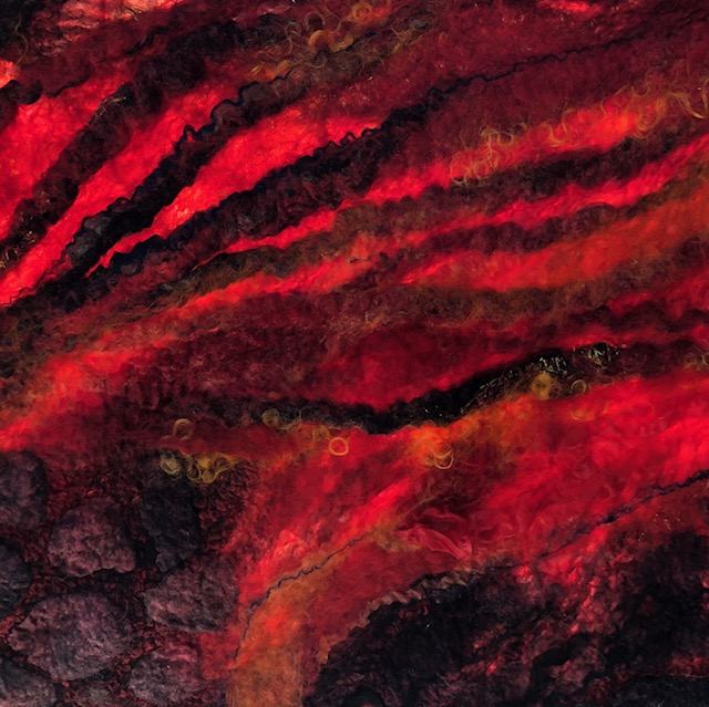 detail of scarlet red and black nuno felt in sunlight